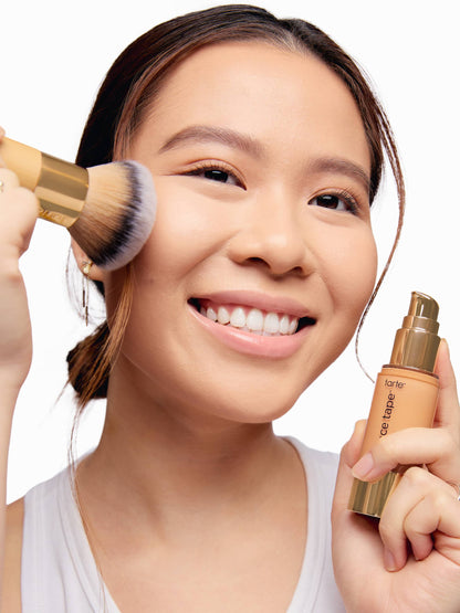 Woman applying makeup with buffer brush